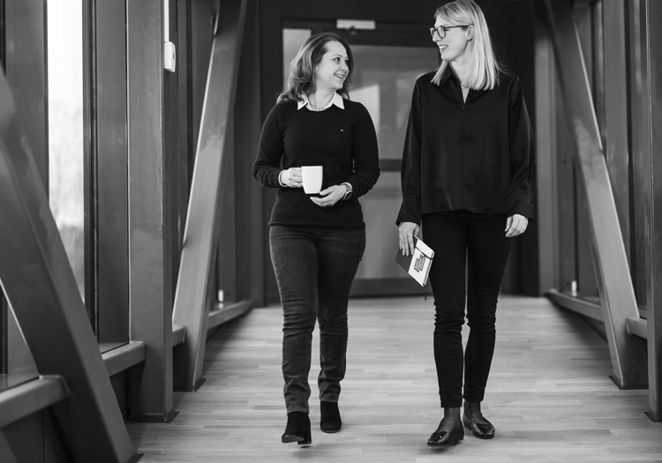 Två personer som går i en kontorskorridor