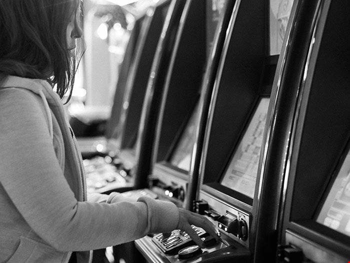 Kvinna spelar vid spelautomat