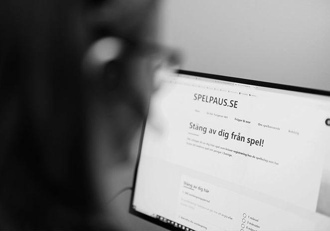 Person som sitter vid sin dator och tittar på webbsidan för Spelpaus.se